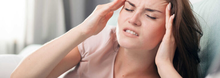 Woman appearing to have a headache due to Bruxism.