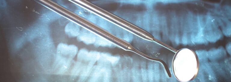 X-ray image with dental tools in front.