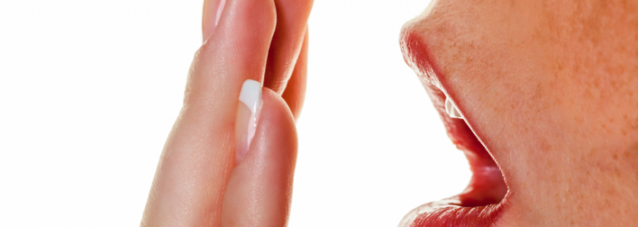Bad Breath - Person holding hand to mouth.